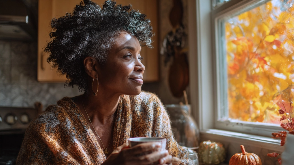 Woman looking outside at Fall landscape